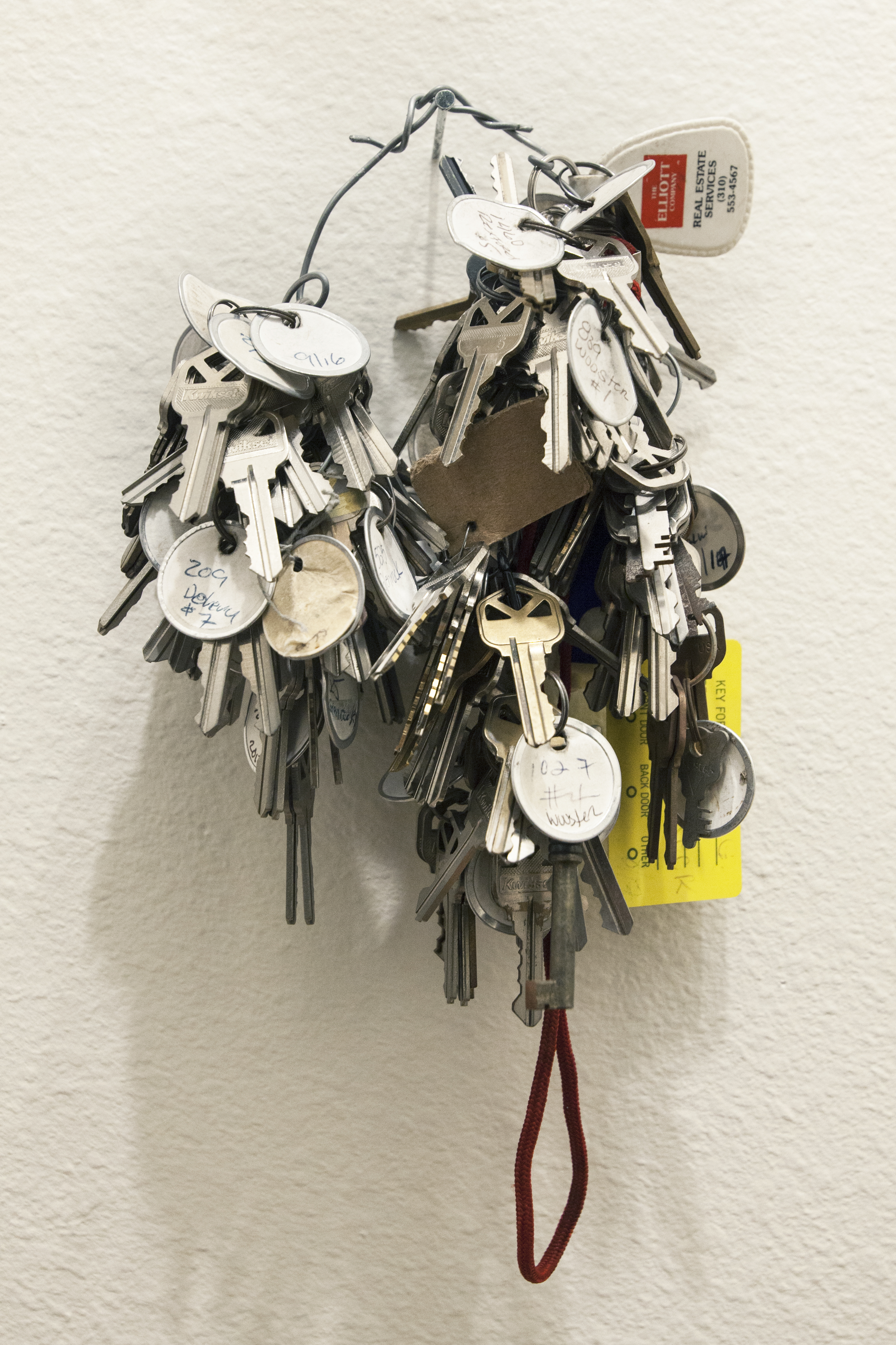 A ring with a large volume of keys on it hung on the wall